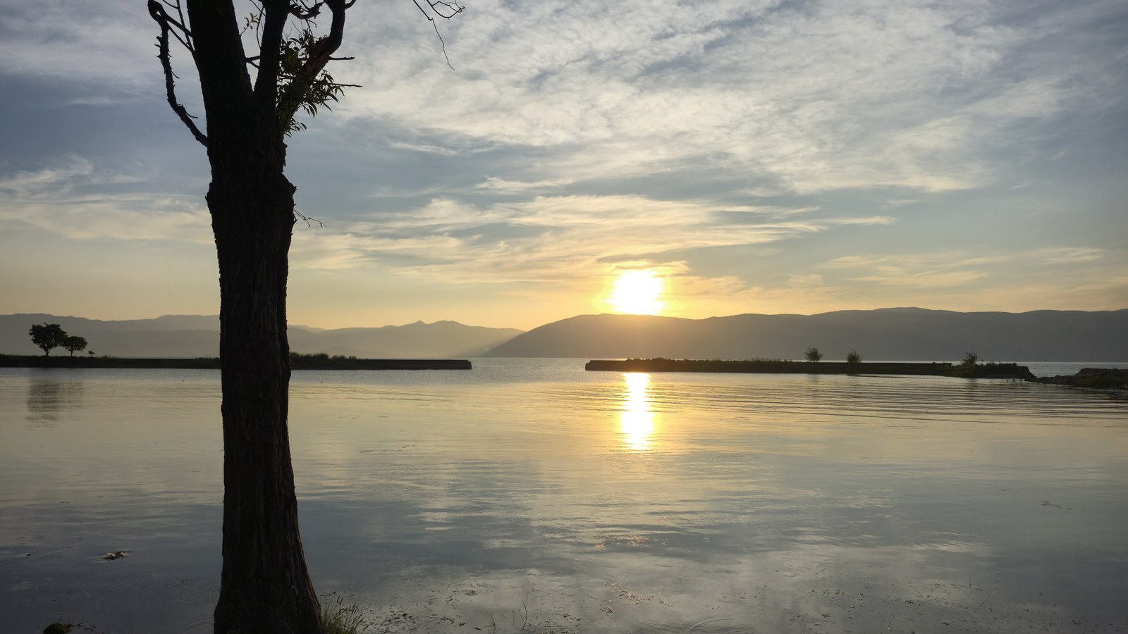 Sunset over the water and mountains near Dali