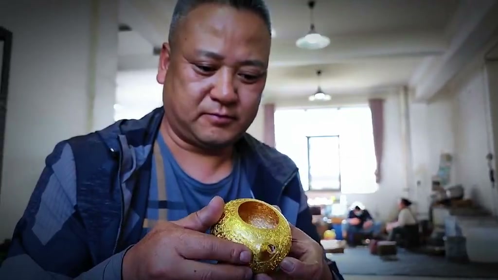 Cun Jinwen examining a finished gold-inlaid silver piece