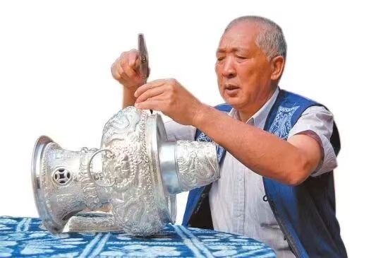 Dong Zhonghao working on a large silver vessel