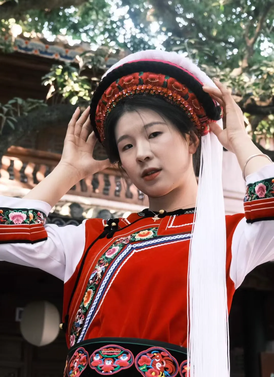 Bai girl holding her Wind-Flower-Snow-Moon headdress