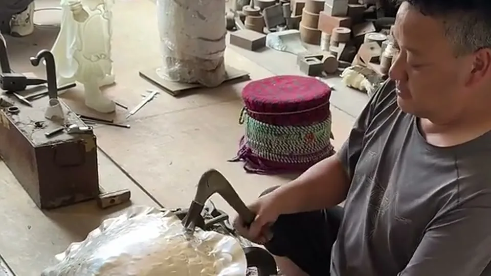 Craftsman hammering silver in workshop