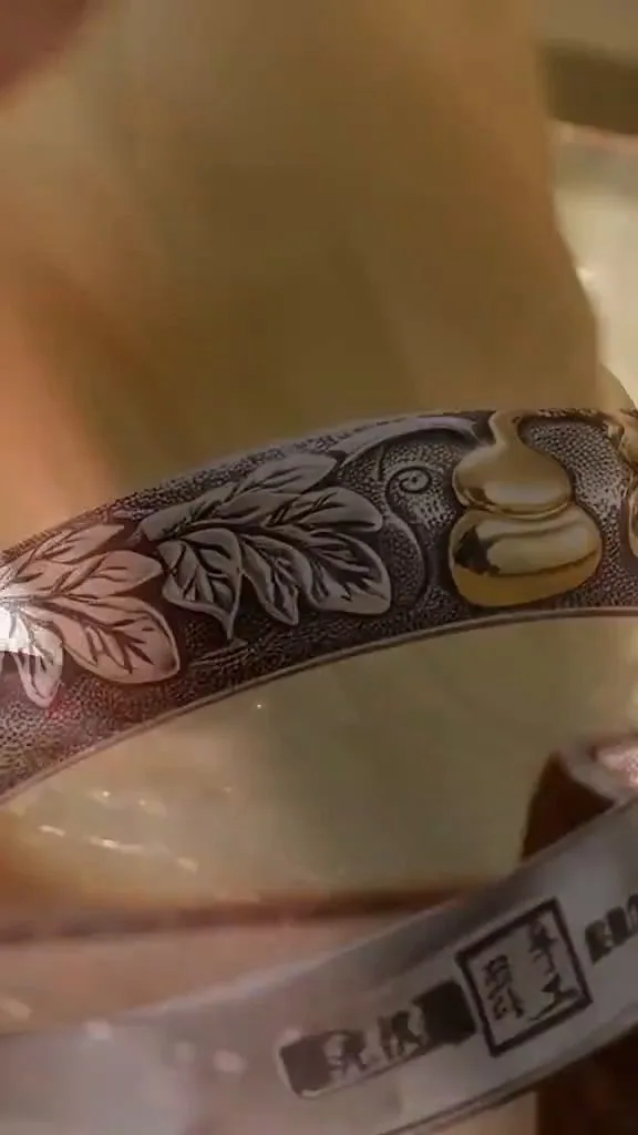 Close-up of hand-chased floral and gourd motifs on silver bangle showcasing Yunnan ODM jewelry design craftsmanship