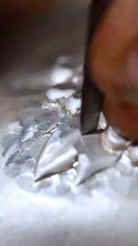 Chisel cutting into silver — every pattern in 999 fine silver is hand-chased