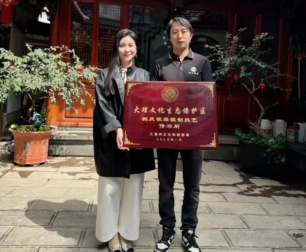 Yang Sheng and a visitor presenting a plaque for a Dali silverware craft training centre